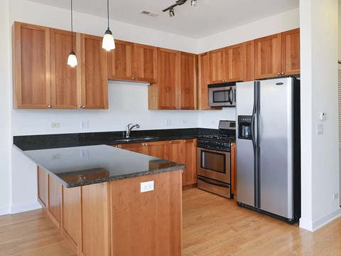 A kitchen with wooden cabinets and a black countertop.