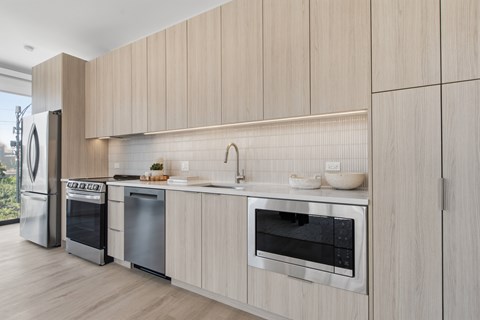 A modern kitchen with wooden cabinets and stainless steel appliances.