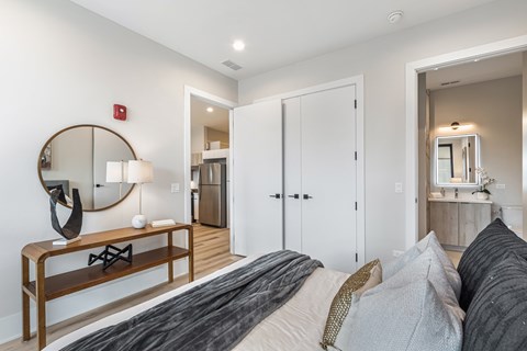 A bedroom with a large bed and a mirror on the wall.