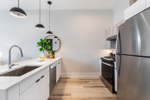 A modern kitchen with a stainless steel refrigerator and a sink with a faucet.
