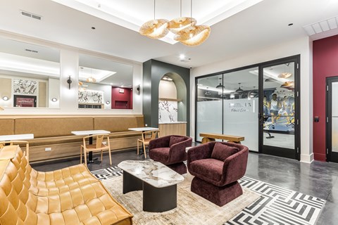A modern living room with a yellow chair and a maroon armchair.