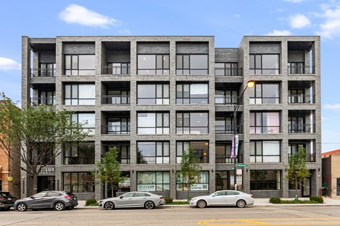 A modern building with cars parked in front.