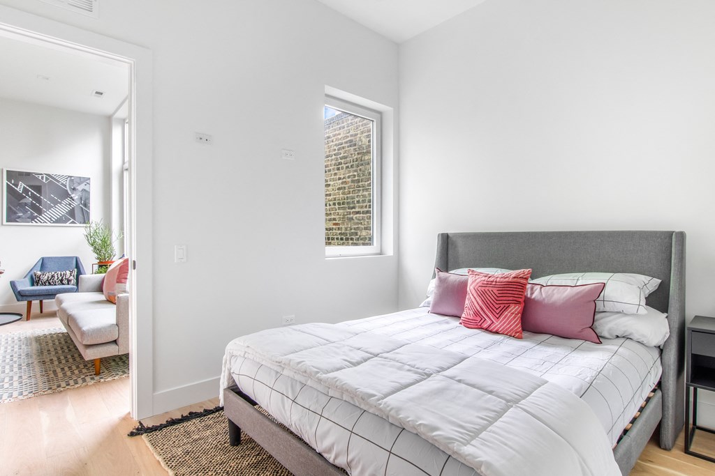A bedroom with a large bed and a window.