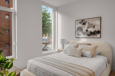A bedroom with a large bed and a painting on the wall.