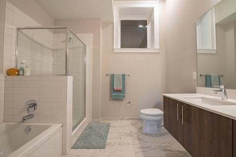 A bathroom with a white tub, toilet, and sink.