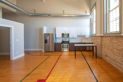 A kitchen area with a brick wall and a wooden floor.