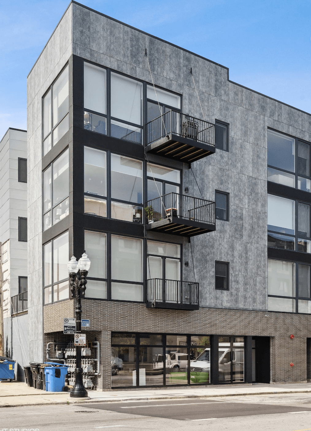 A modern building with a black and white facade and a balcony on the second floor.