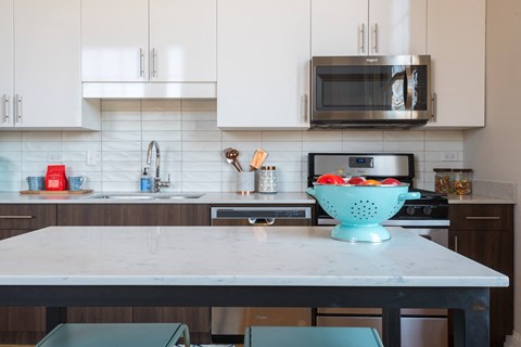 A kitchen with a bowl of fruit on the table.