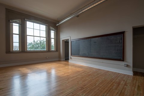 A room with wooden floors and a large window.