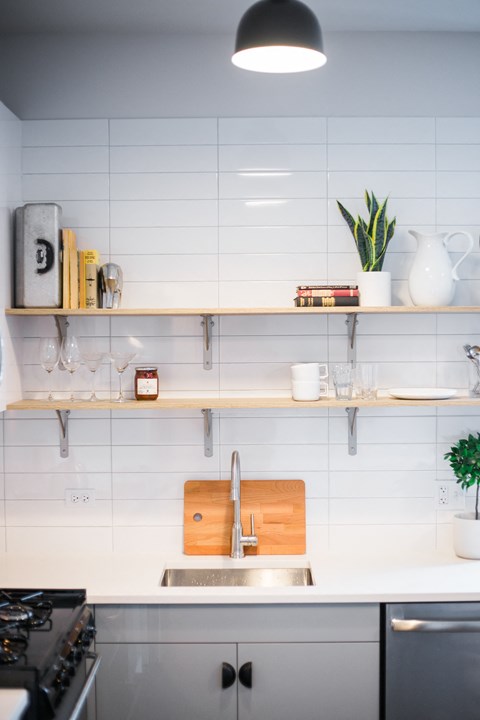 A kitchen with a white countertop and a black stove top.