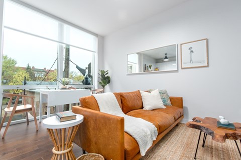 A living room with a brown couch and a white table.