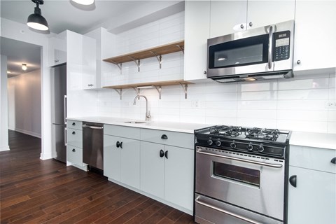 A modern kitchen with white cabinets and a black stove top.