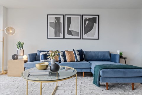 a living room with blue couches and a glass coffee table