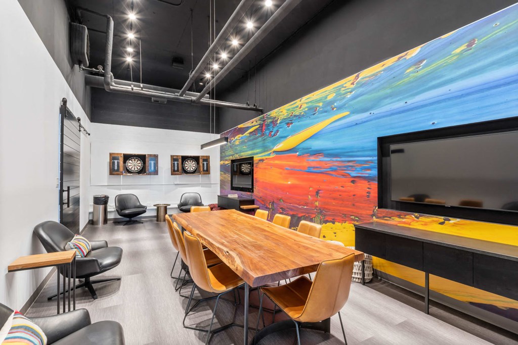 a conference room with a large painting on the wall and a table with chairs