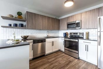 a kitchen with stainless steel appliances and a wood floor
