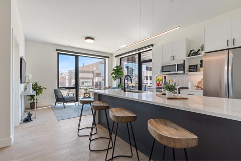 a kitchen with a counter and three stools