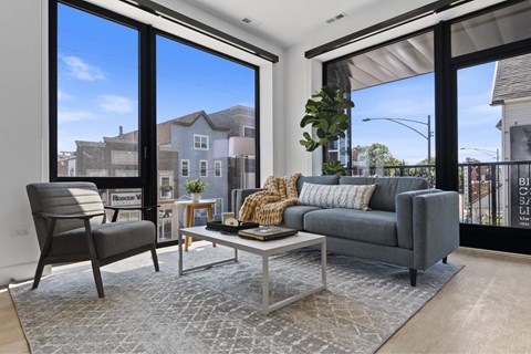 a living room with large windows and a couch and a coffee table