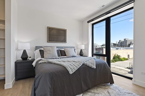 a bedroom with a bed and a large window
