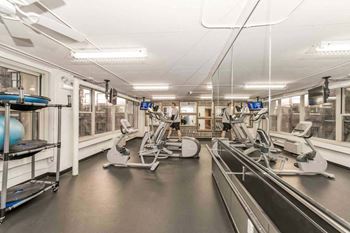 a gym with cardio machines and weights in a building