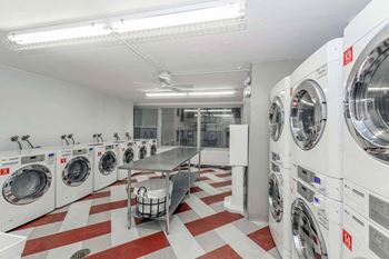 a washer and dryer laundry room with a table and chairs and washing machines