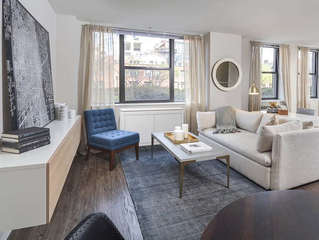 A living room with a blue chair and a white couch.