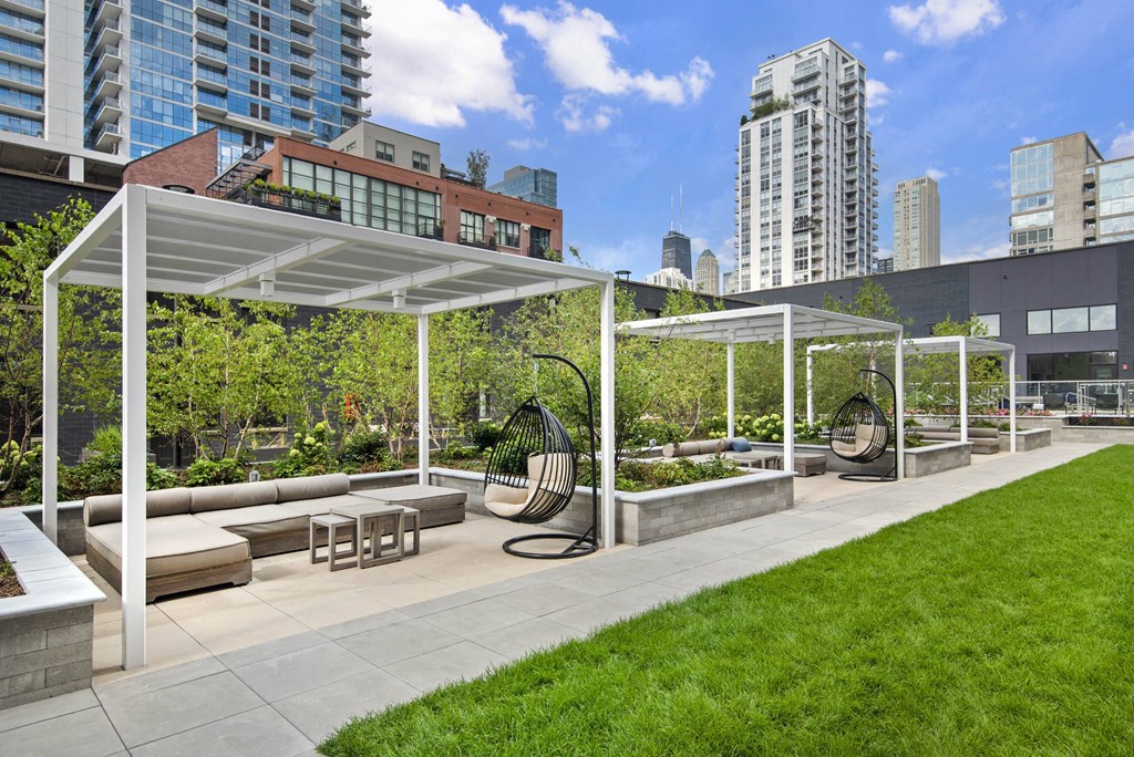 A park with a white canopy and a bench.