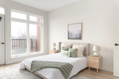 A bedroom with a large bed and a picture on the wall.