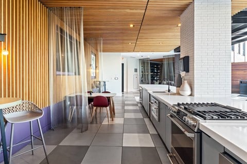 A modern kitchen with a wooden slat wall and a white counter top.