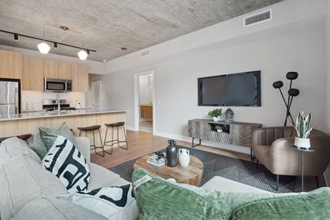 A modern living room with a grey couch and a wooden coffee table.