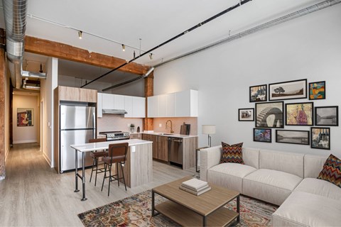 A modern kitchen and living room with a white couch and a coffee table.