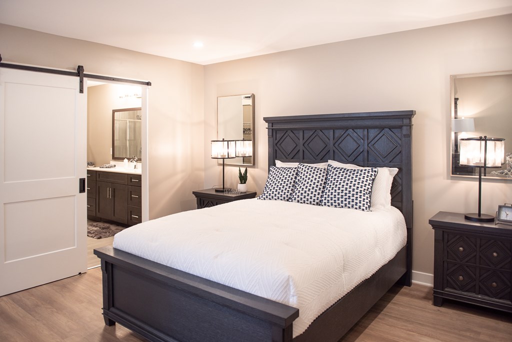 Typical primary bedroom with plank flooring and ensuite bathroom (actual layout may vary)