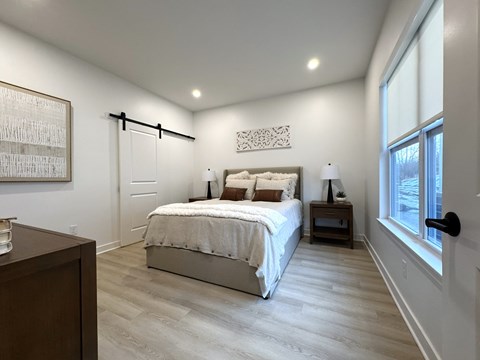 Typical primary bedroom with sliding barn door to en-suite bathroom & walk-in closet