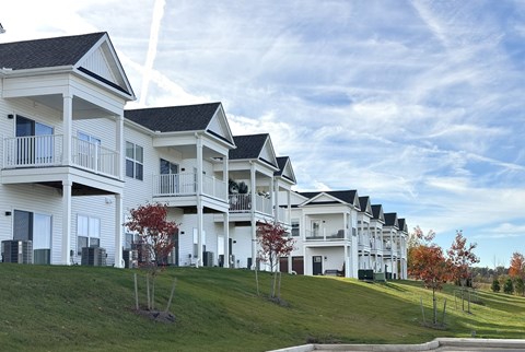 Erie Ridge exterior view of apartments showing upper units with balconies and lower units with private patios on a hillside