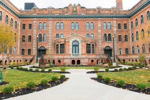 a large brick building with a courtyard in front of it