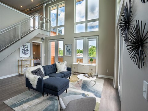 a living room with large windows and a blue couch