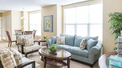 a living room with a couch and chairs and a table
