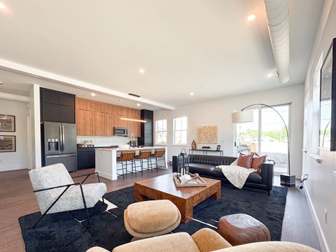 A modern living room with a black couch and a wooden coffee table.
