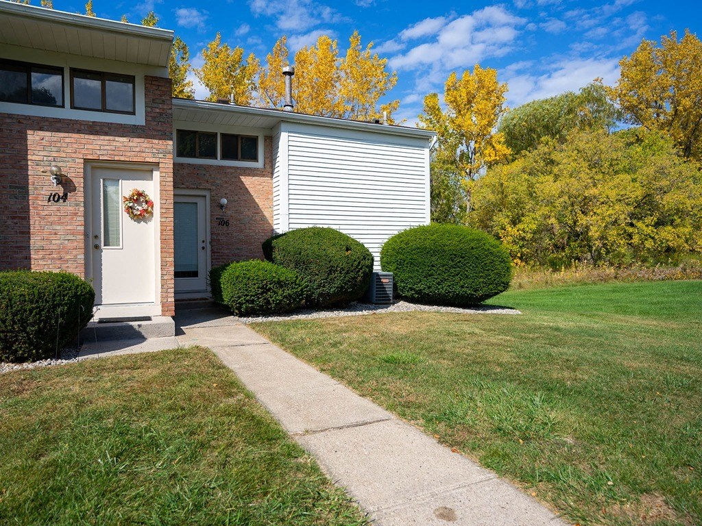 a sidewalk in front of a house with a white door