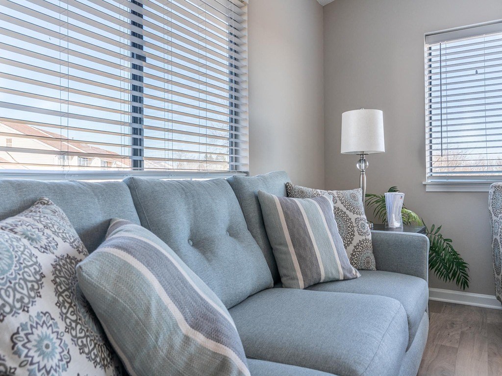 a living room with a couch and two windows