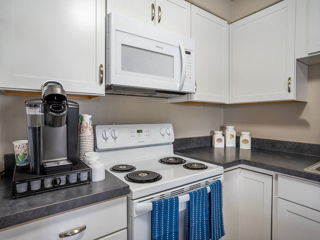 a kitchen with white appliances and white cabinets