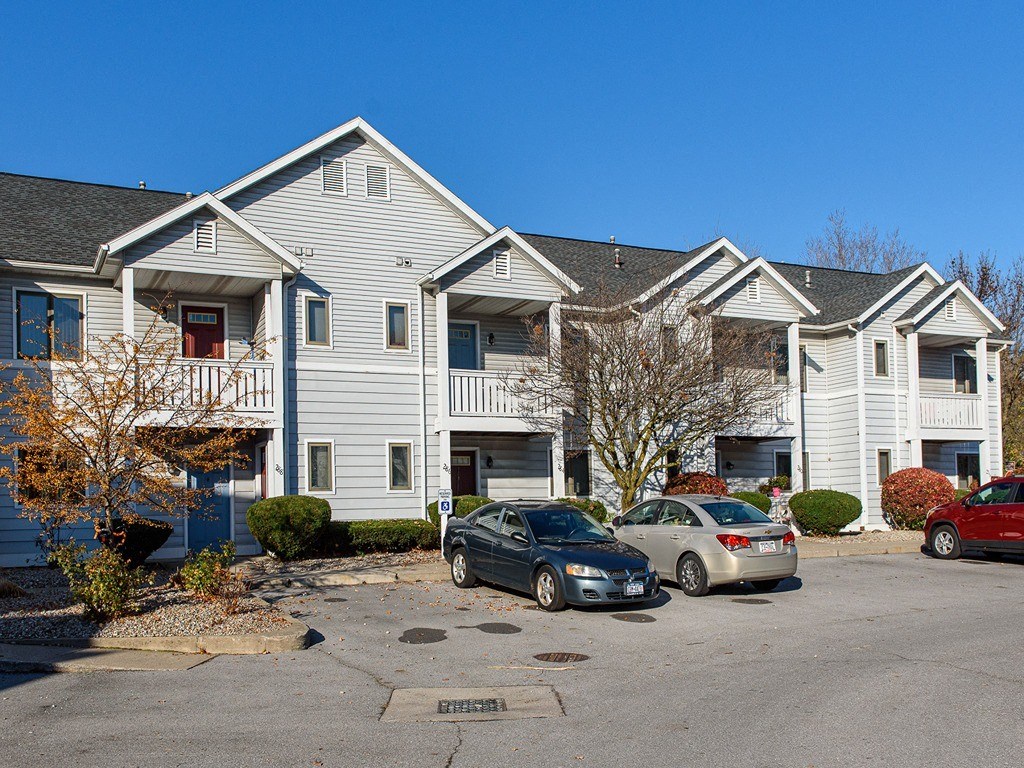 a row of houses with cars parked in front of them