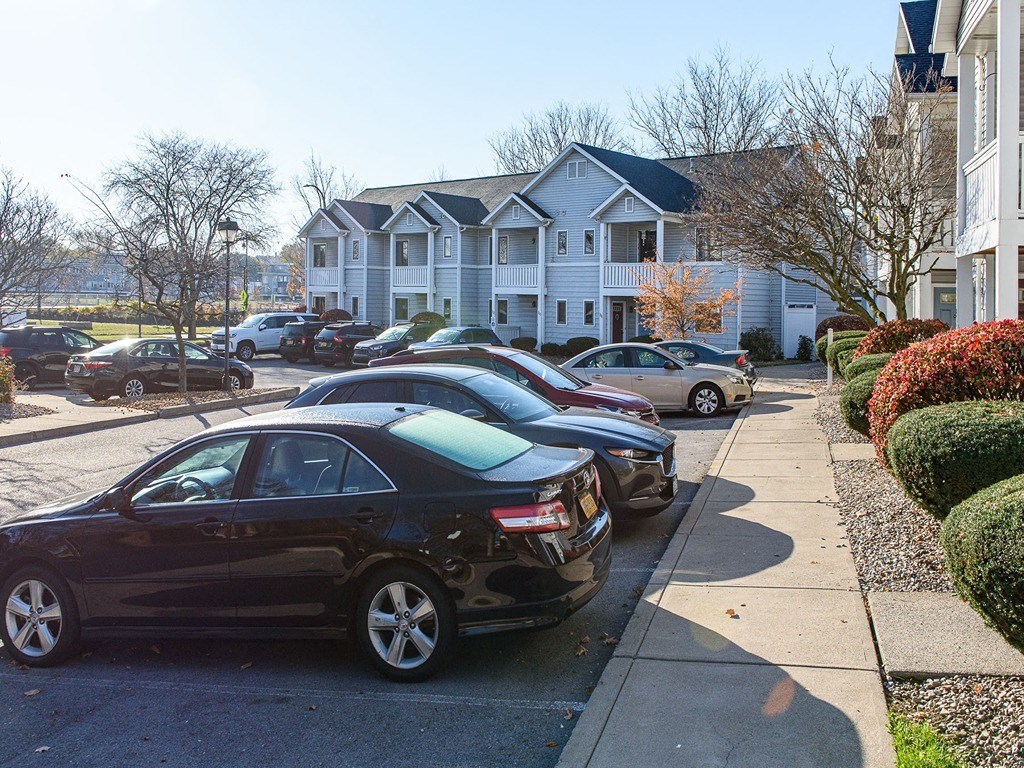 a row of cars parked on a street in front of houses