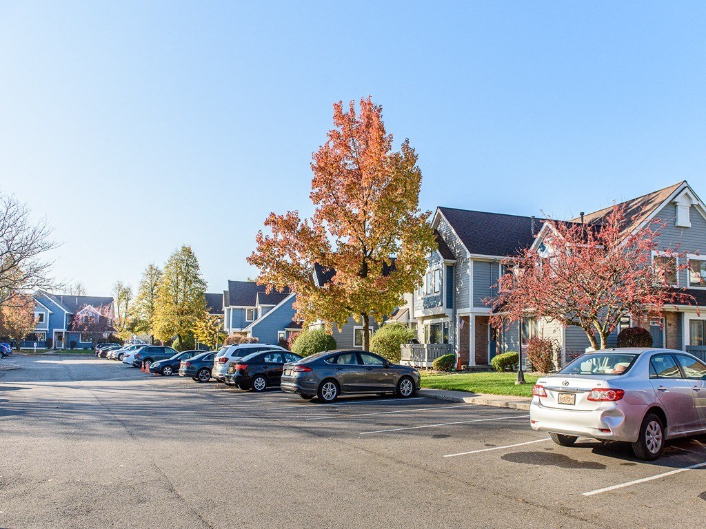 a parking lot filled with cars in front of houses