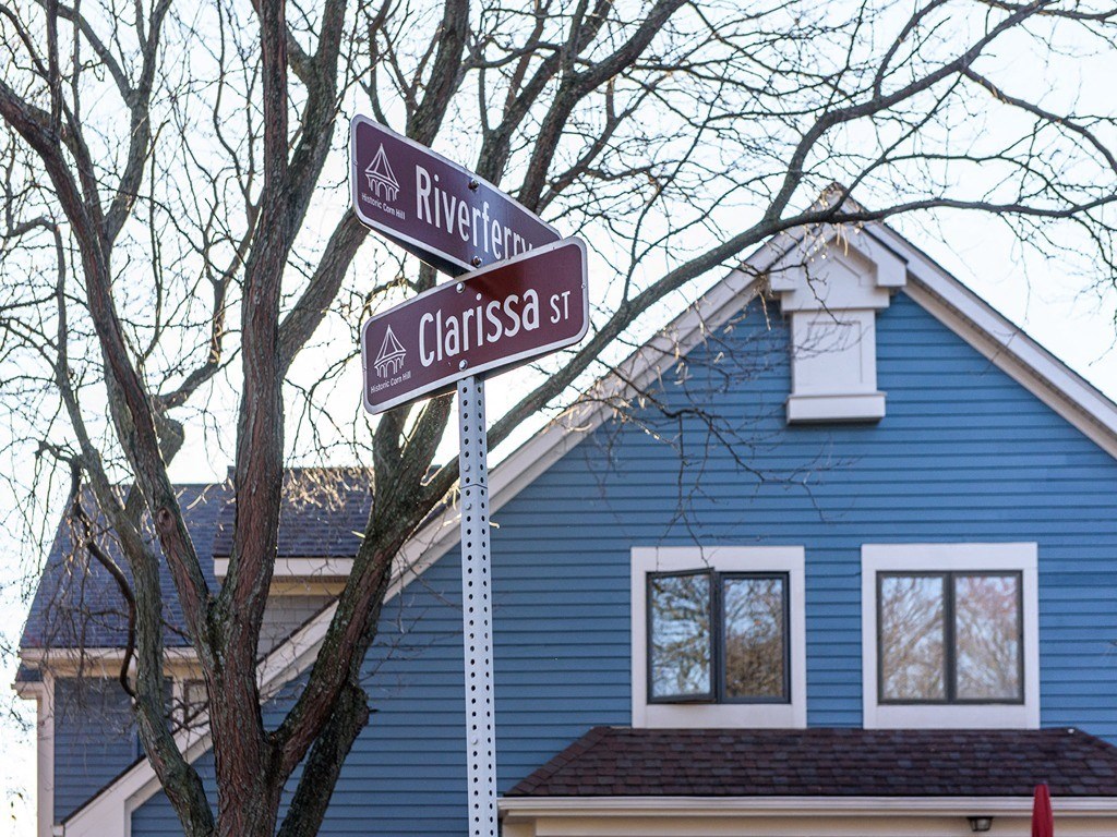 two street signs in front of a blue house
