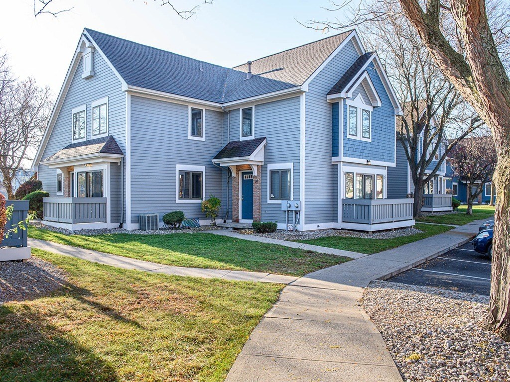 a blue house with a sidewalk in front of it