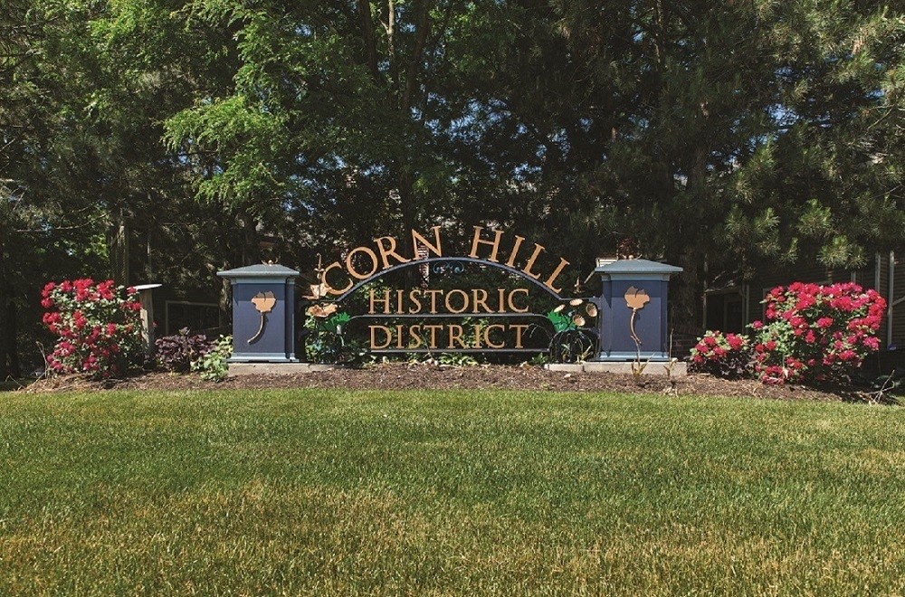 a sign for the coron hill historic district in front of a field of grass