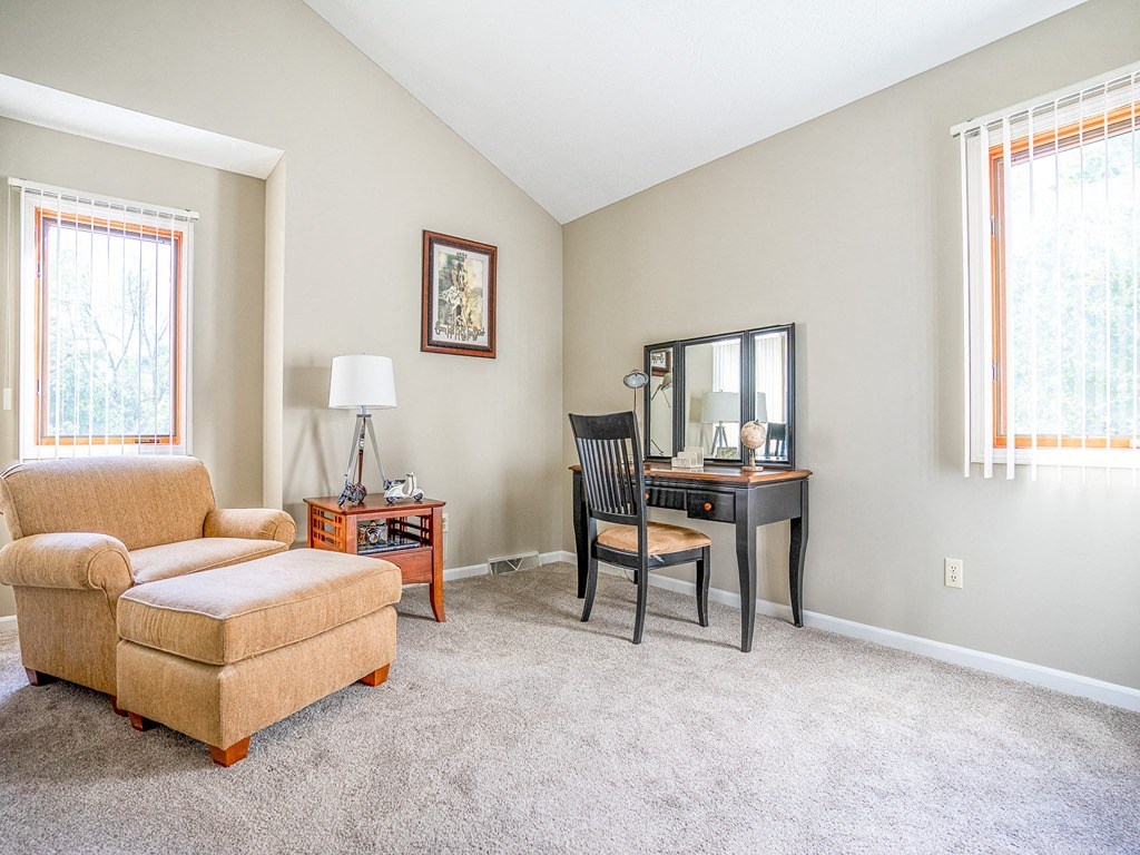 a living room with a couch and a chair and a desk