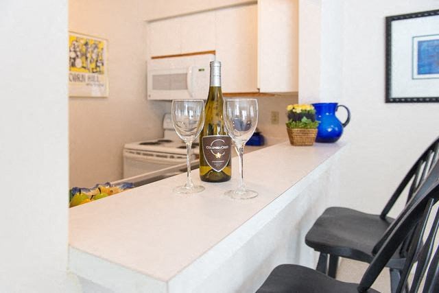 a kitchen counter with wine glasses and a bottle of wine
