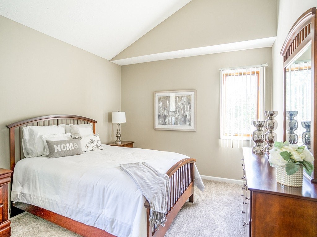 a bedroom with a bed and a dresser and a window