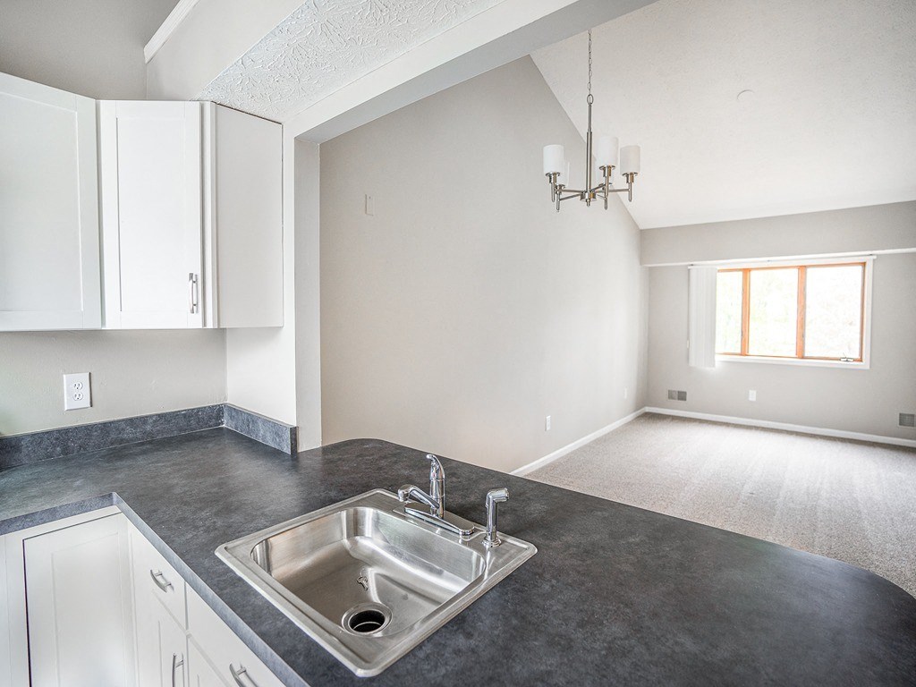 an empty kitchen and living room with a sink